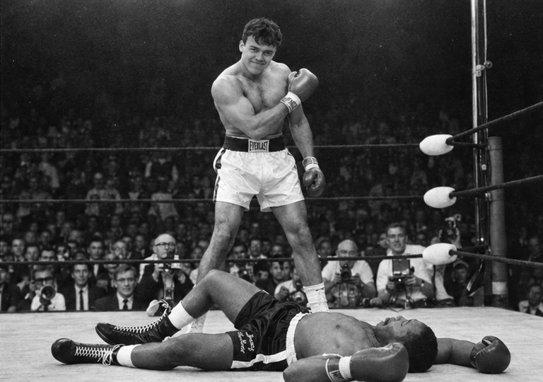 joakim .h standing over a floored opponent in a boxing ring, looking pleased with himself